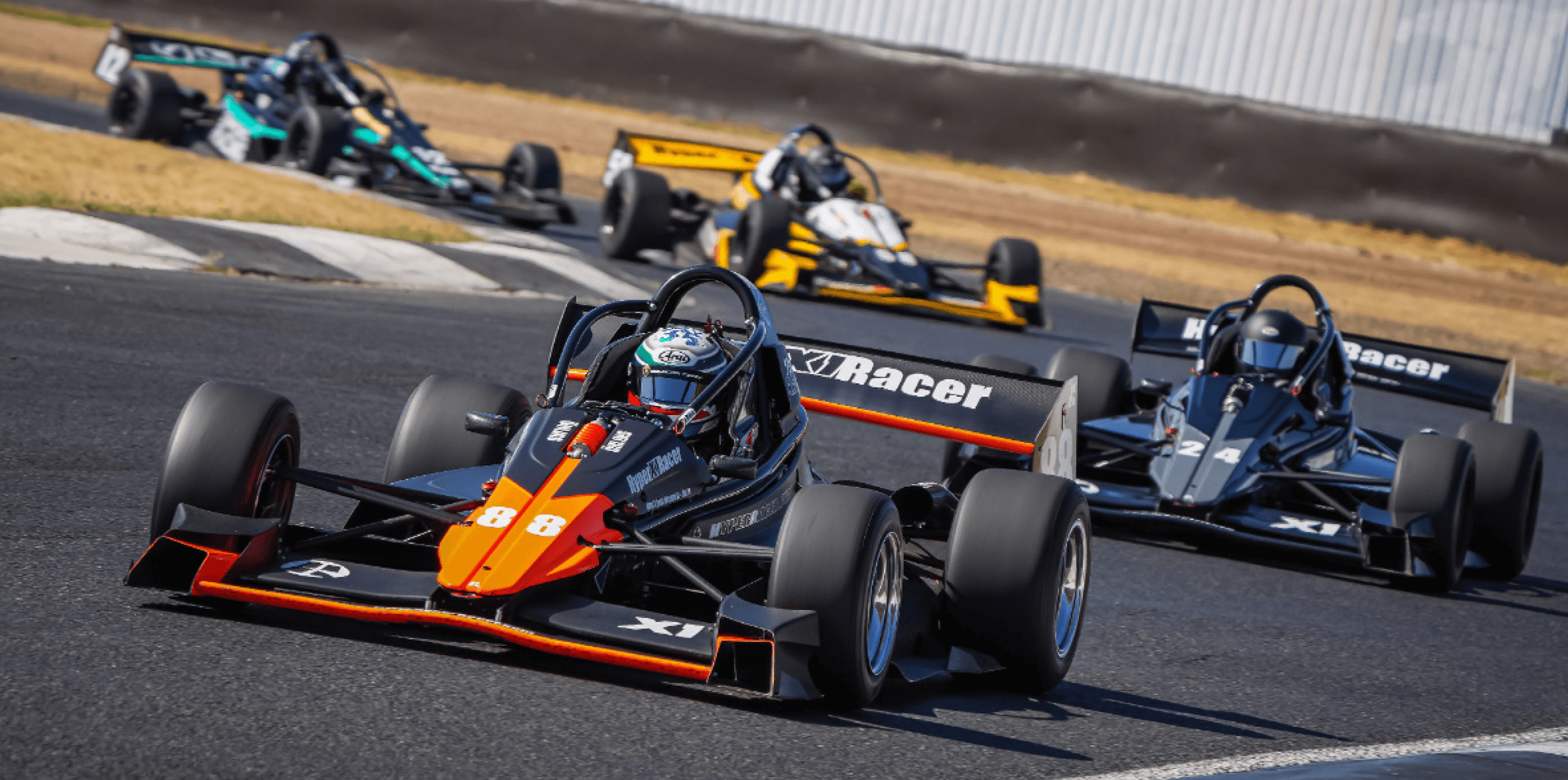 Orange #8 X1 leading four cars through a corner