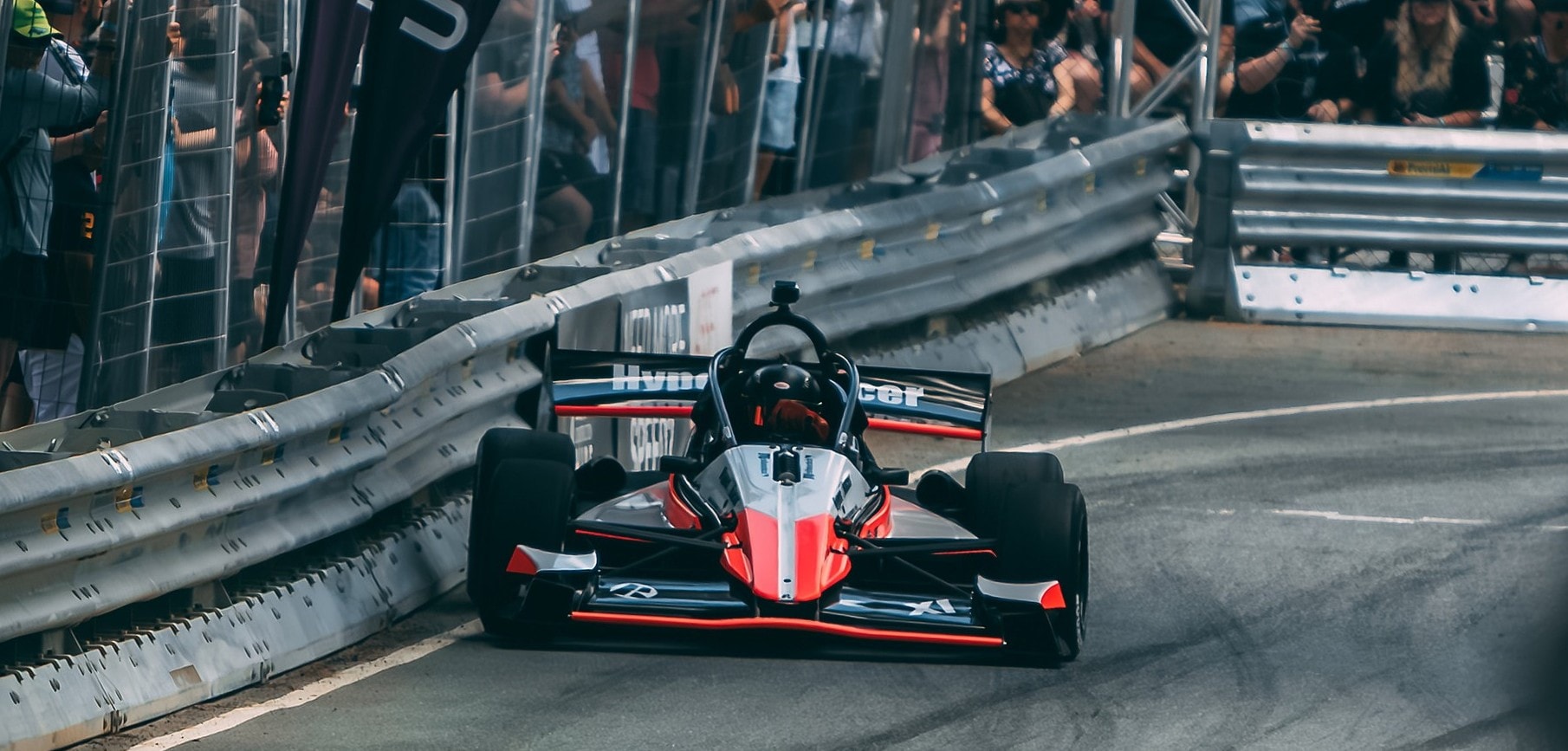 Red and black X1 head-on at a street circuit