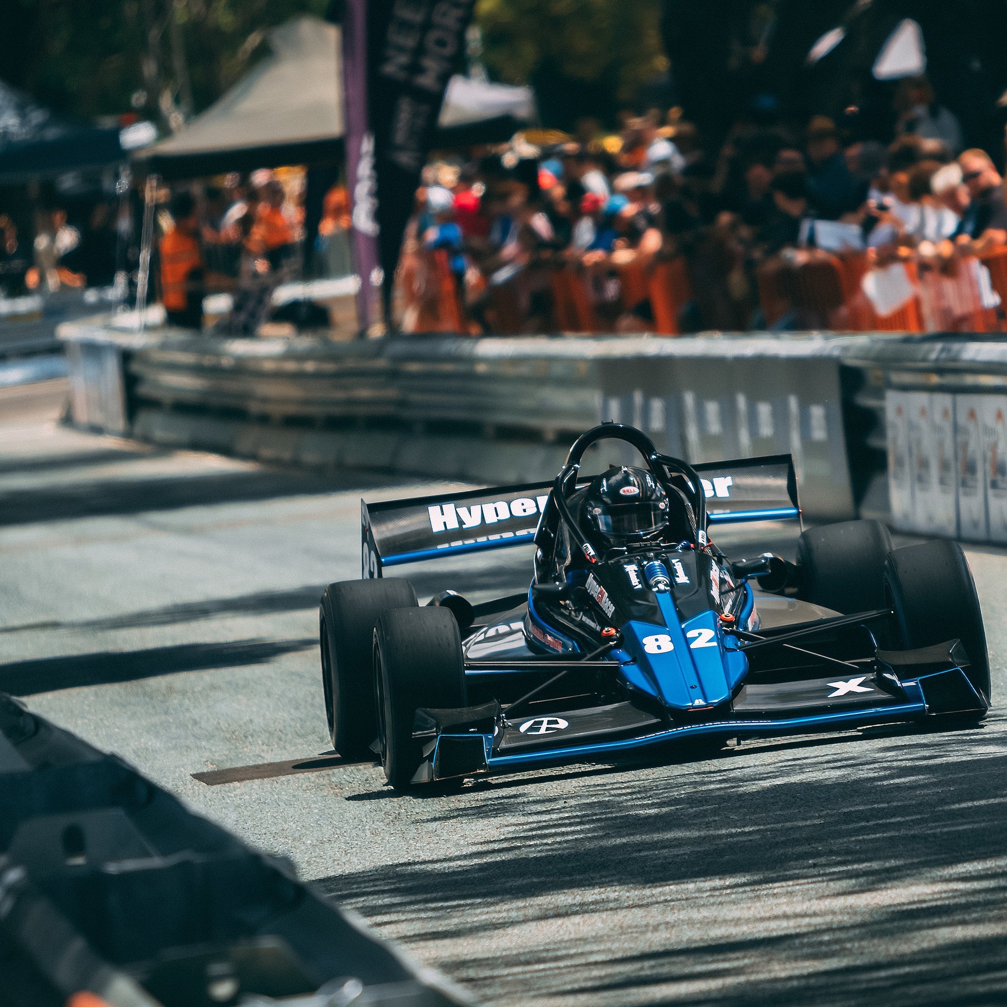Blue #82 X1 at a street race with crowd