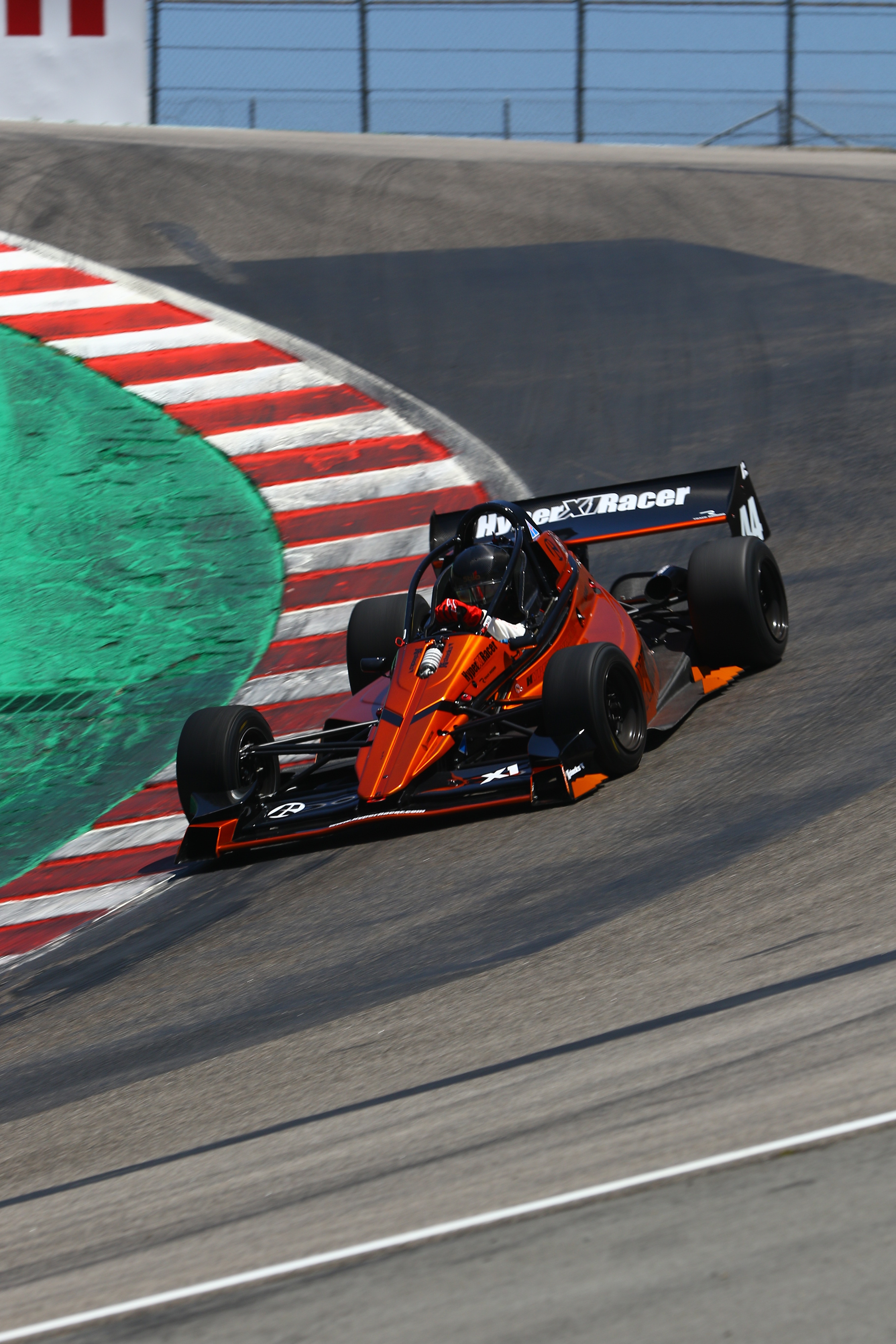 Orange X1 through the turn at Laguna Seca
