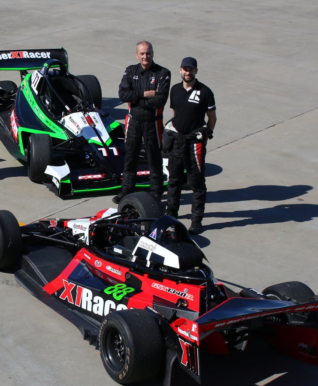 Jon and Dean Crooke — 3rd and 4th generation founders of Hyper Racer — standing with their X1 race cars